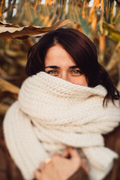 Young woman with her face covered in a cozy scarf.