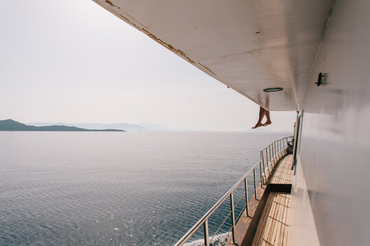Dangling legs over the side of a boat.