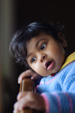 Adorable toddler contemplates resting her head on her hand