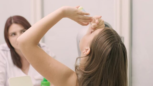 The young girl instill eye drops before installing Night time Contact Lenses in an ophthalmologist's office. Eyedropper putting liquid into open eye. Child's eye drops.