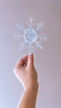 Hand holding a snowflake