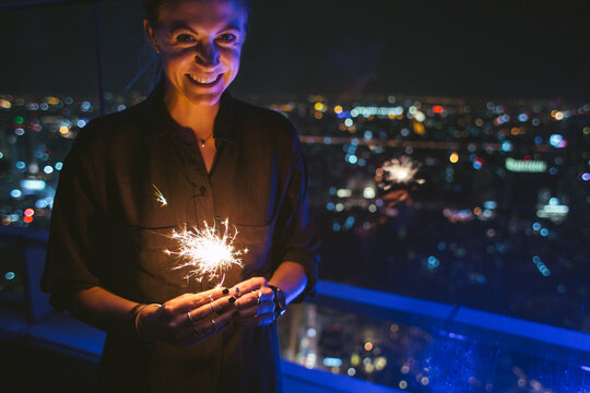 Happy woman holding a sparkler