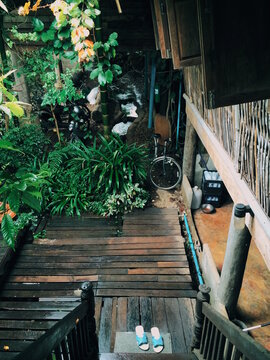 pair of sandal shoes at bottom of staircase in old thai house