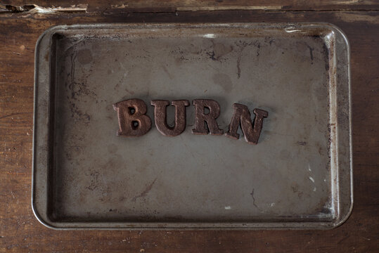 Shortbread Cookie Letters that have been burnt to a crisp, spelling out the word "burn"
