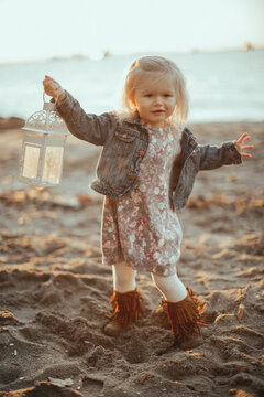Toddler on the beach play with a latern