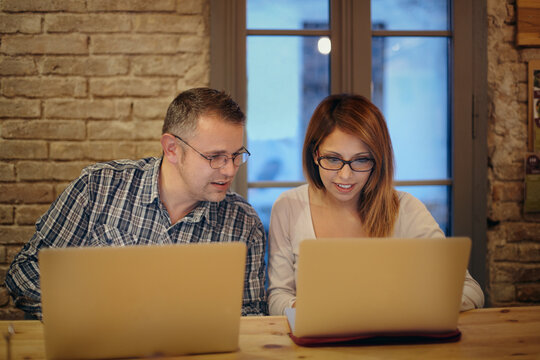 Interacial couple with two laptops in a coffee shop