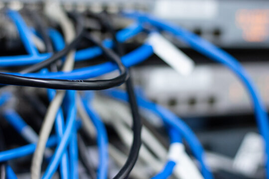 Close Up Of Messy Blue, Black And Grey Network Cables  Plugged Into A Switch