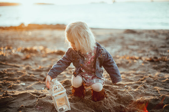 Toddler on the beach play with a latern