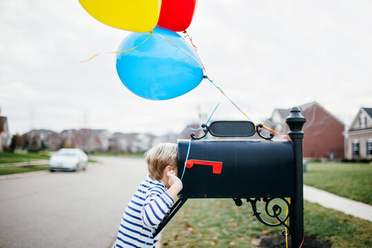 Child Looking For A Birthday Surprise Inside His Mailbox