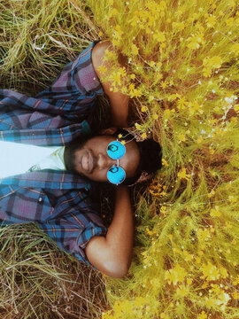 Mobile phone portrait of a guy laying in flowers.