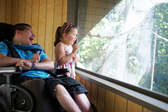 Little Girl and Young Man in a Wheelchair looking out a window at the Melbourne Zoo