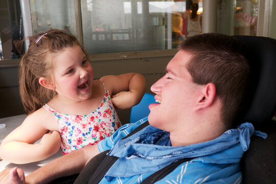 Five-year-old girl sharing a joke with a Young Man