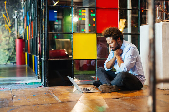 Young entrepreneurs working sitting in the floor in a creative office.