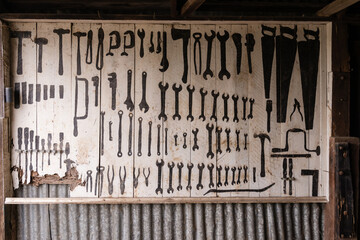 a run down tool shed with large template board