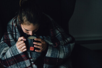 young woman drinking tea in the evening