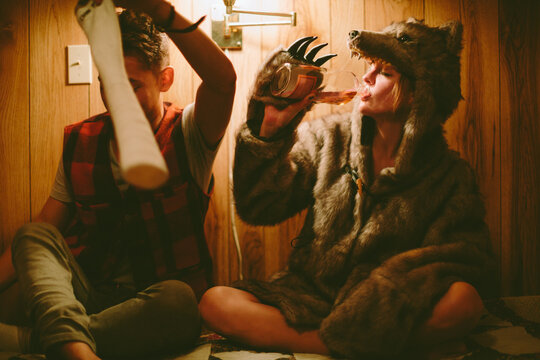 Young friends sit up and drink in bed together