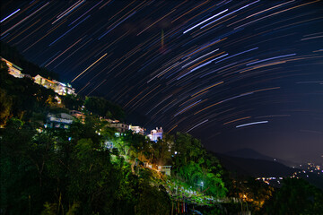 star trails from a himalayan town on a winter night