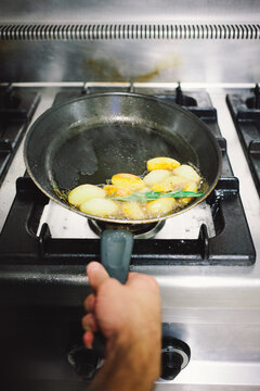 Potatoes being fried in a saucepan