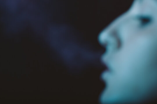 Profile of woman smoking, out of focus