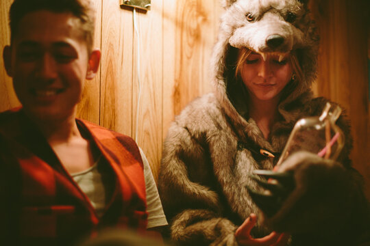 Two young friends enjoying a bottle of alcohol in bed