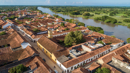 Aerial view of the historic town Santa Cruz de Mompox in sunlight with river and green sourrounding, World Heritage