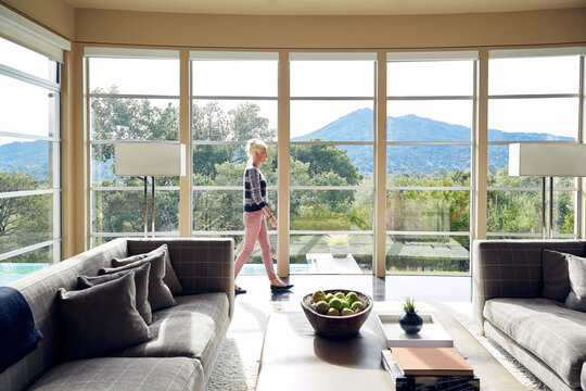 Mature woman relaxing in luxury home living room with view