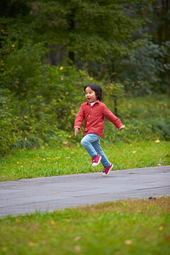 little asian girl running in the park