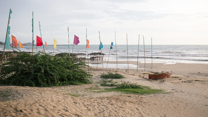 Boat parked in a seaside village partially adorned by colorful flags and banners
