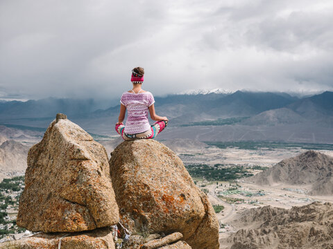 Yoga Girl Meditating on top of Mountains