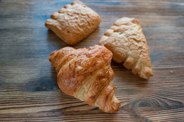 Puff pastry croissants on a wooden background.