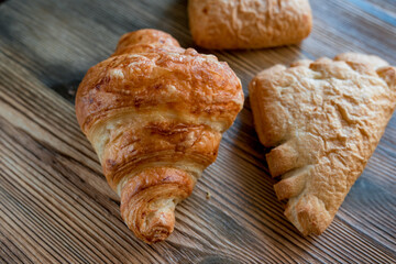 Puff pastry croissants on a wooden background.