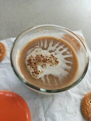 A cup of milk chocolate on a white background with crispy cake in a city park.