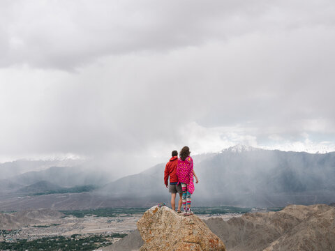 Couple standing on top of mountain and looking far away