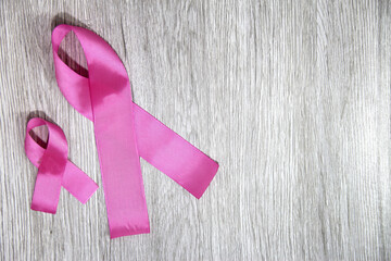 pink ribbon for campaign against breast cancer on vintage wooden background