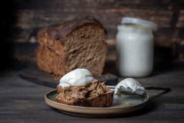 Sliced bread and sour cream on wooden table, close up