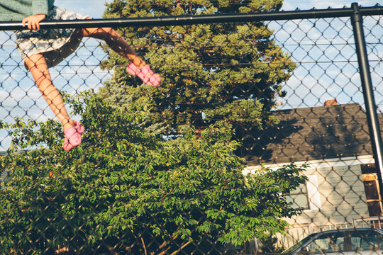 Six year old girl climbing over chain link fence