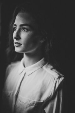Pretty woman in white button up shirt, septum piercing and long dark hair