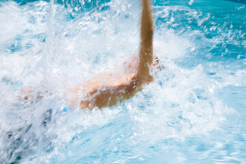 Young boy in a swim meet doing a backstroke