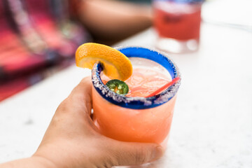 hand holding a grapefruit jalapeno margarita