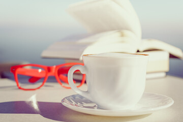 Coffee cup and books outdoors