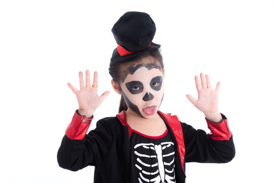 Little asian girl dressing skeleton haloween costume with face painting over white background.