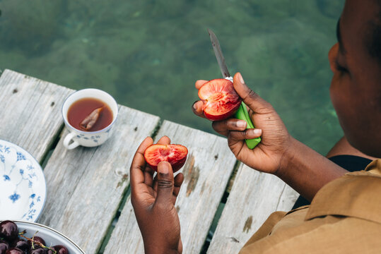 Woman cutting stone fruit on the dock