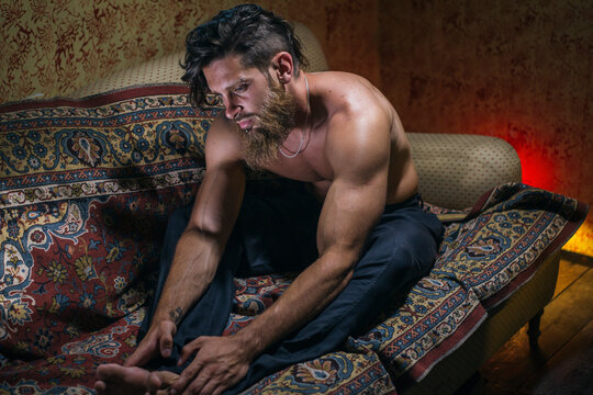 handsome hipster man lying on the sofa in a dark room