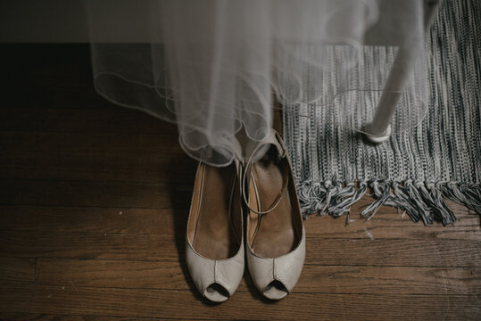 Vintage bridal wedding shoes on wood floor with veil