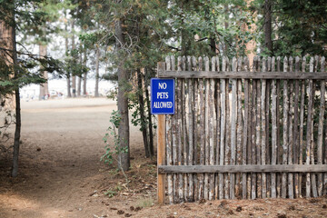 No Pets Allowed"" sign on a wood fence