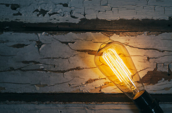 Light: Antique Incandescent Bulb Lays On Peeling Painted Wood
