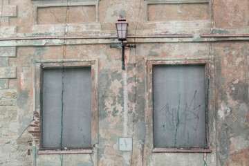 Decaying boarded up house covered with a protective net, just a lantern sticking out