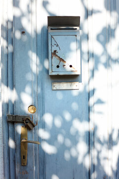 Old door with mailbox and a lock