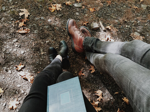 A man and a woman reading a book on a fall day