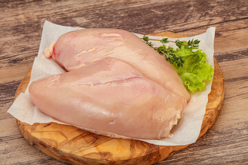 Raw chicken breast over board